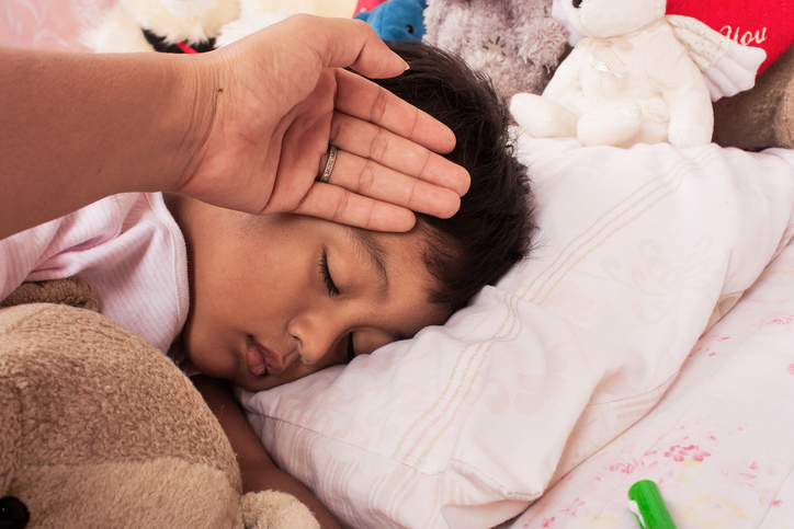 enfant malade au lit avec de la fièvre, la mère s'occupe de lui